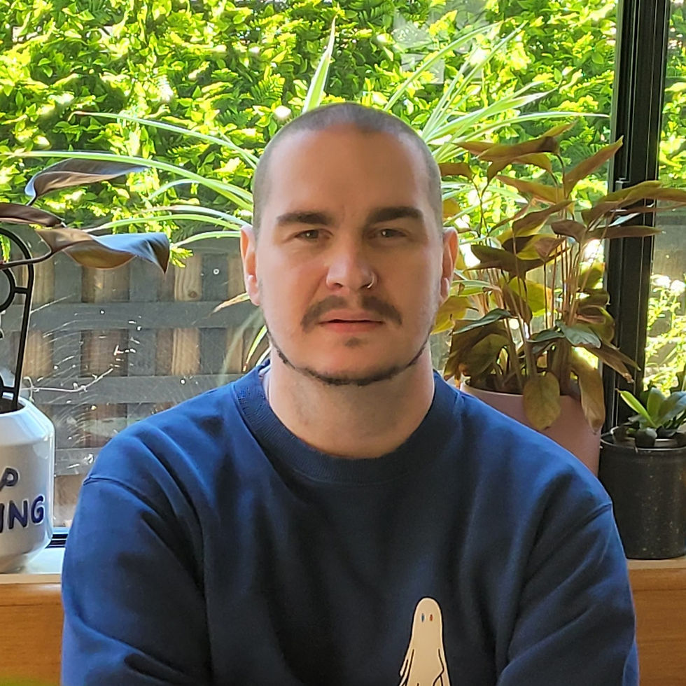 British DJ L-J Louis standing with arms crossed looking at camera, colour image.