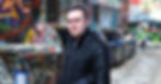 Portuguese DJ Joshua standing on a street in Melbourne, Australia covered in Graffiti, colour image.