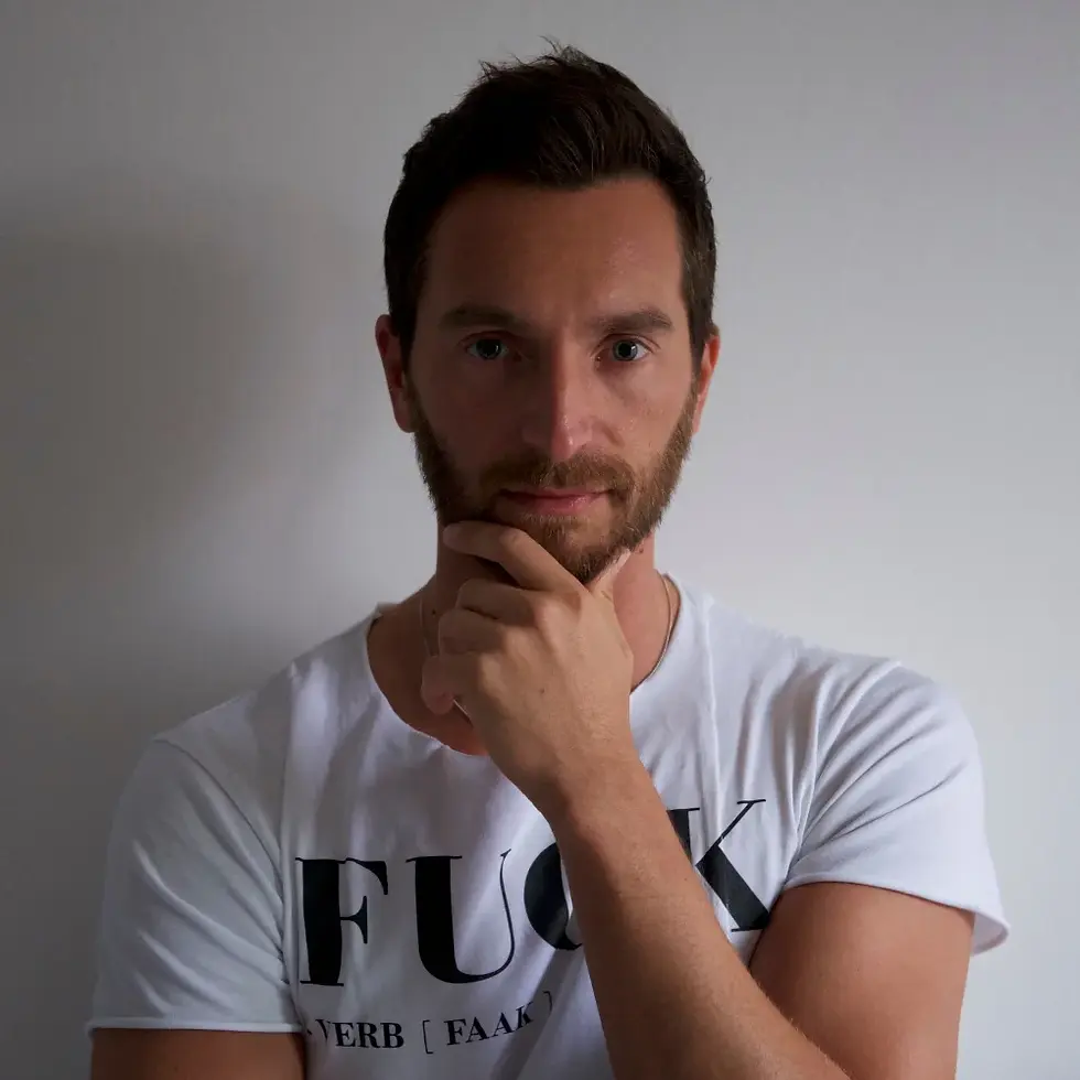 Italian DJ and producer INVE standing looking at camera with his left hand on his chin, colour image.