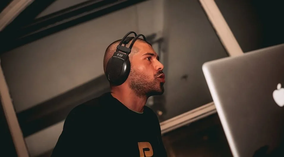 Romanian DJ Bipolar Bear preforming as a DJ wearing headphones and looking towards the crowd.