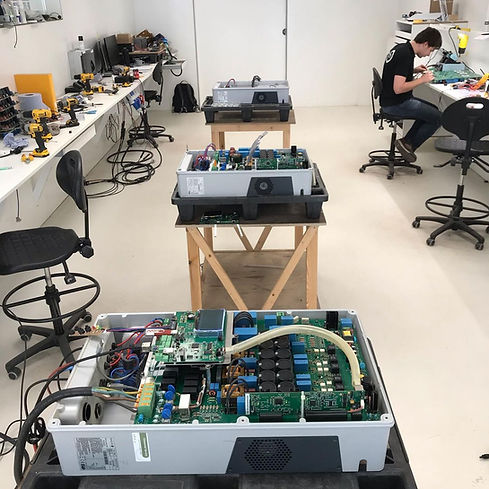 Vue de 3 onduleurs photovotlaiques ouverts et en attente de réparation dans le laboratoire Service Onduleur