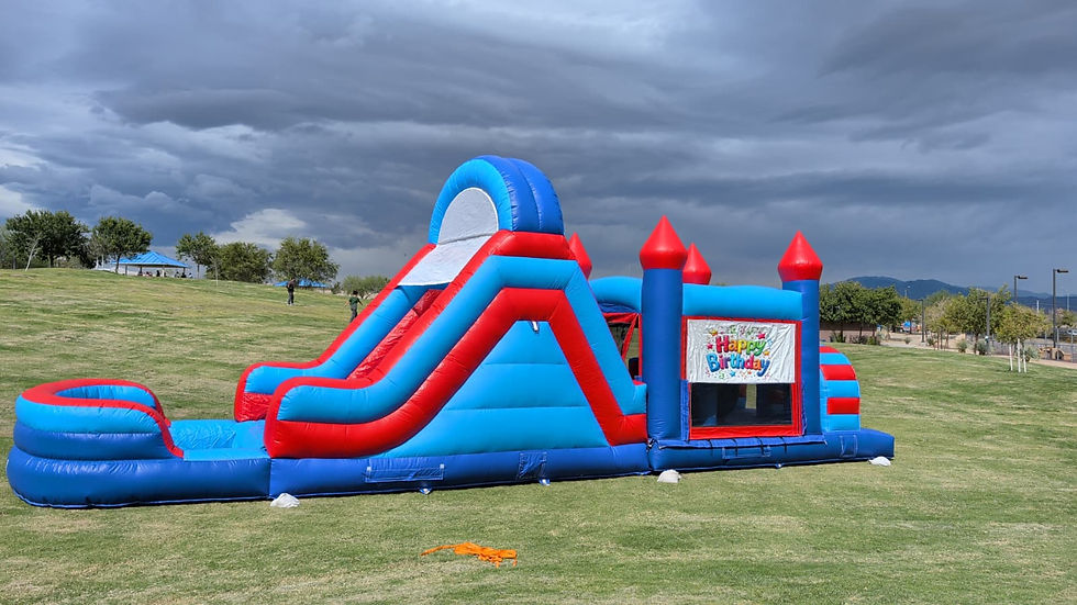 Red and blue inflatable obstacle course and slide on grass