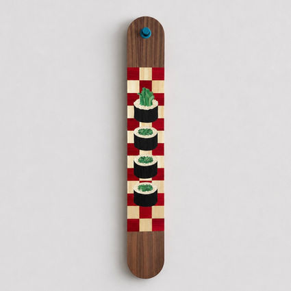 Contemporary straw marquetry artwork shaped like a long tag made of walnut, featuring a cut sushi roll on a red and white checkerboard background with a blue eyelet. food art