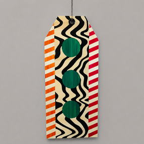 Contemporary straw marquetry artwork shaped like a luggage tag made of plywood, featuring a wavy pattern in black and white along with three green circles and orange and pink stripes with a black eyelet. food art