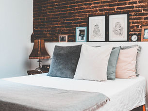 Uma cama com várias almofadas em um quarto rústico mas aconchegante