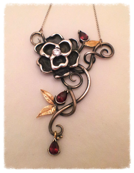 Silver floral pendant with garnets