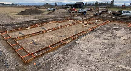 Bright orange plastic Accufooting braces installed on footing forms and ready for concrete to be poured.