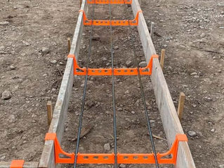 AccuFooting's orange plastic concrete footing braces on wood frame ready for concrete pouring.