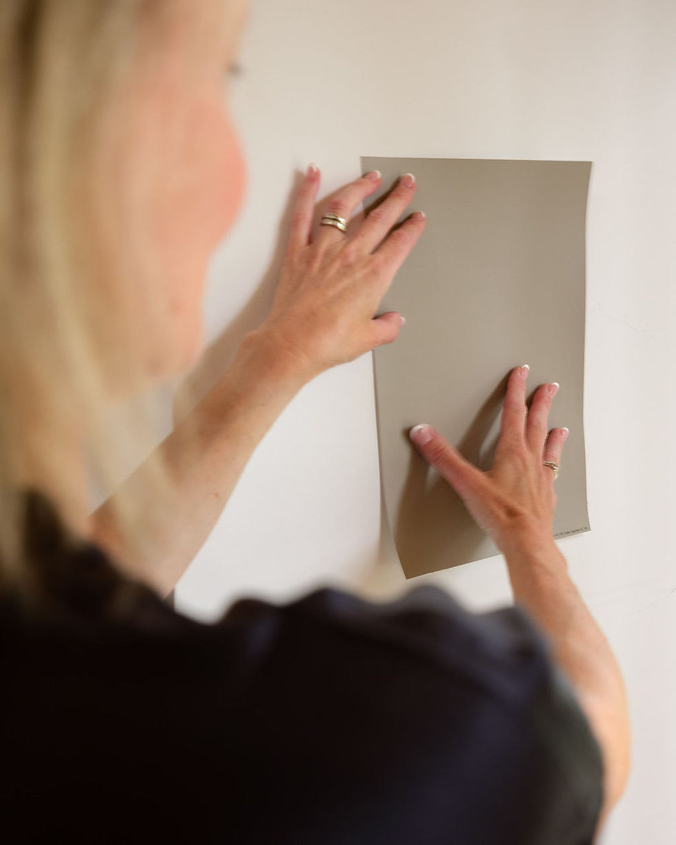 Interior designer comparing paint colour in samples during a home design consultation in Summerland, BC.