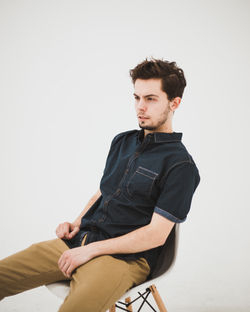 Casually dressed man modeling on chair