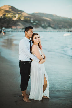 Smiling couple embrace each other at Malibu beach