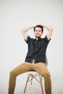 Man running hands through hair smiling on chair