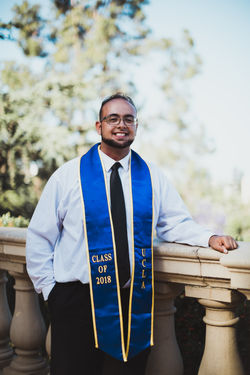 Smiling man with graduation sash over shoulders