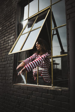 Girl in red and white striped shirt leaning out window