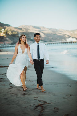 Laughing couple strong along the sandy beach