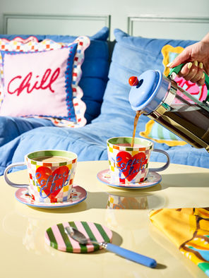 Pouring coffee in colourful coffee mugs