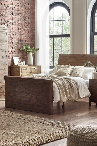 Exposed brick wall interior with wooden bed