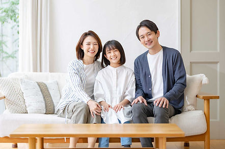 ソファーに座っている三人家族
