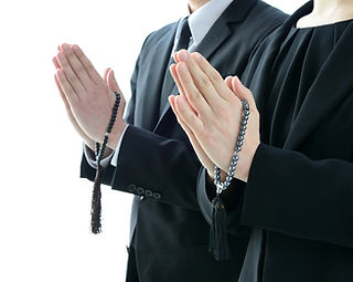 喪服姿で合掌している男女