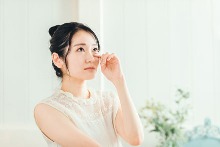 左目の下をおさえる女性