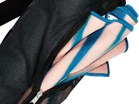 View of the Manduka mat carrier half unzipped with a manduka yoga mat towel sticking out.