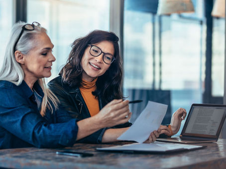A woman talking to a colleague in an office.