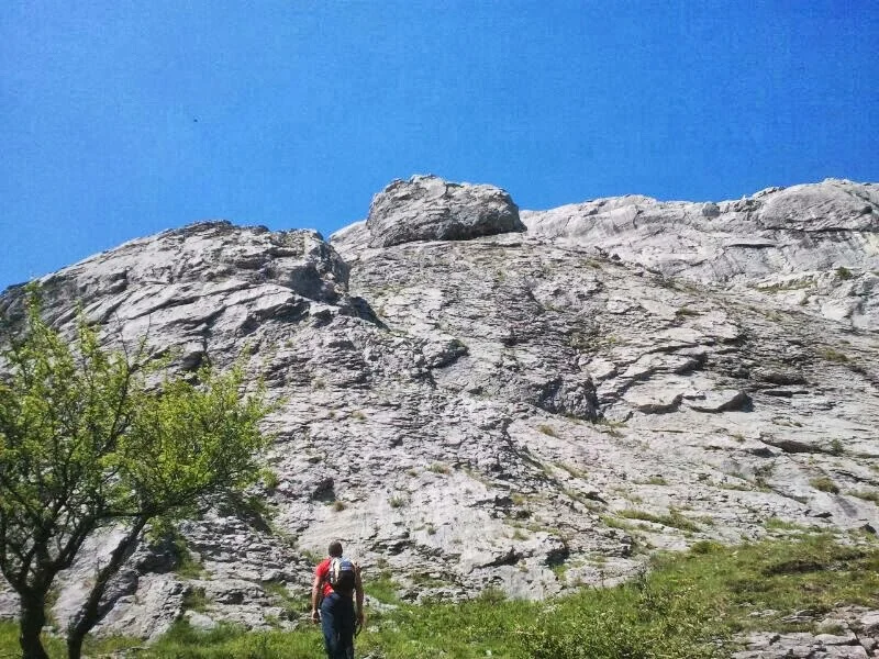 Hiker in front of large rock formation