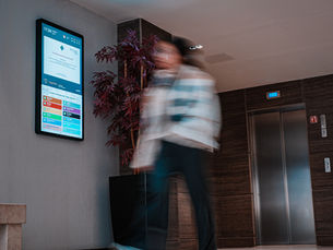 Woman walking past a UK PDOOH screen