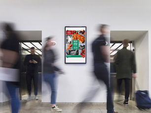 People walking past a real world media screen