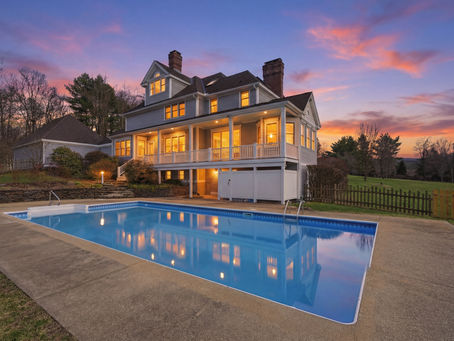 Twilight real estate photography of Amherst MA home with pool and sunset sky by Seven Roads Media