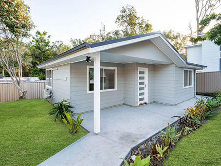 Modern Budgewoi granny flat with gable roof, landscaped yard, separate driveway, and fresh fencing, designed to maximise street appeal.