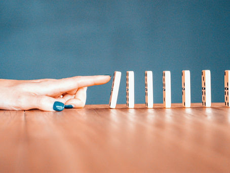 Turquoise wall dominos falling on wood floor
