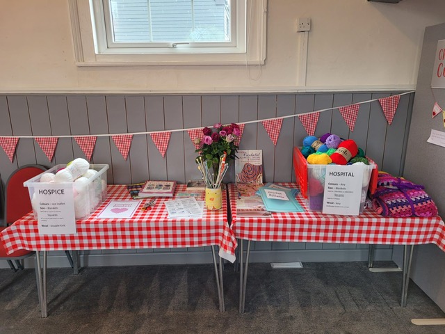 photo of two boxes full of wool on a table with flowers in the middle