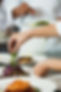 Chefs placing garnish on plated meals