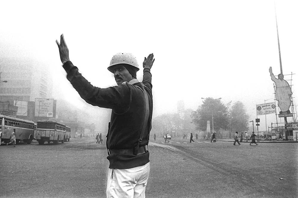 A traffic police officer managing vehicles on a busy street in Kolkata, India.