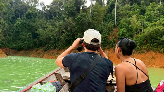 Wildlife photography experience on Cheow Lan Lake with travelers observing the rainforest scenery from a private longtail boat.