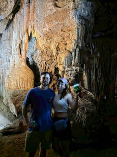 Adventure travelers discovering the dramatic limestone formations inside Coral Cave at Cheow Lan Lake.