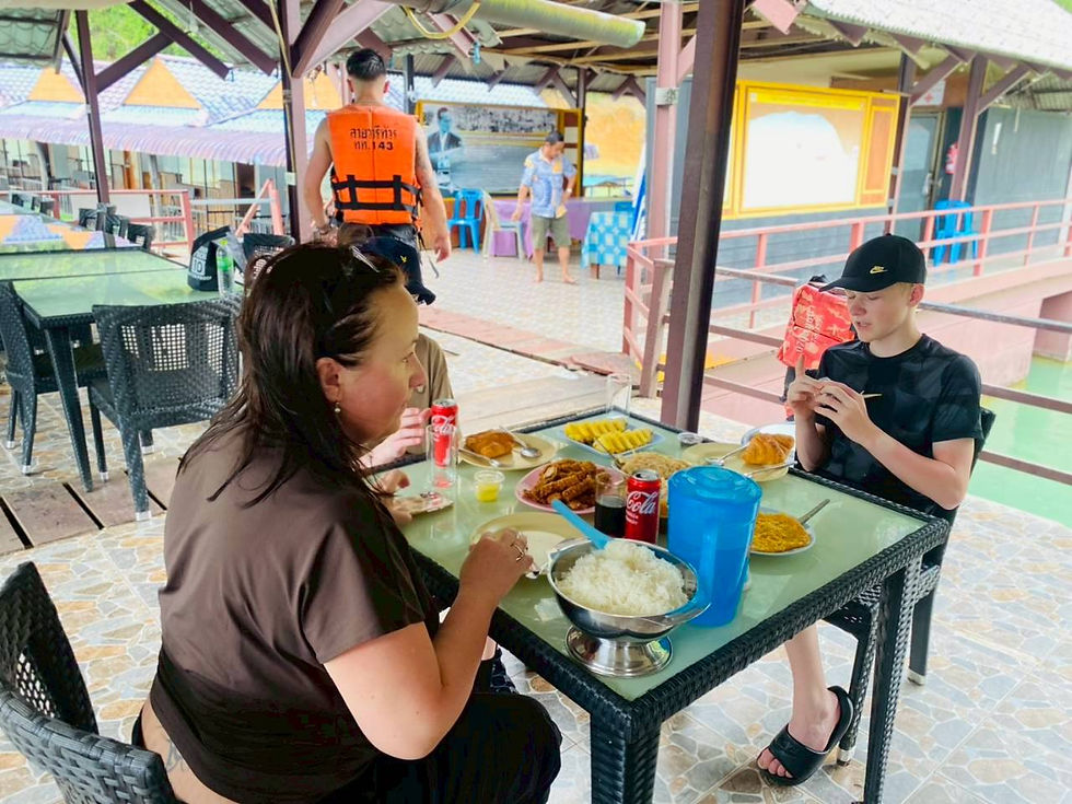 Guests seated together at a lakeside restaurant table.