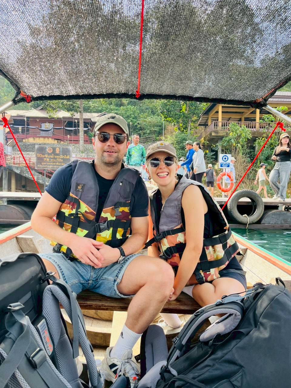 The guests seated together beneath the boat canopy wearing life jackets.