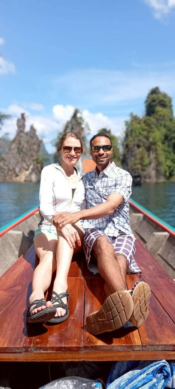 Two guests seated together on the boat with limestone pinnacles behind them.