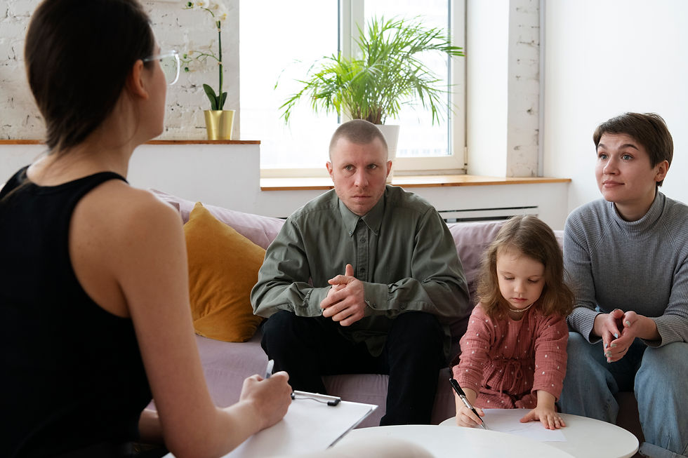 Parents and young child attending a family counselling appointment with a therapist in a welcoming office setting.