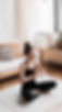 Woman meditating in a sunlit living room, surrounded by a peaceful atmosphere.
