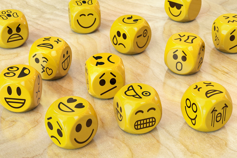 A set of twelve yellow dice with different facial expressions on each face.