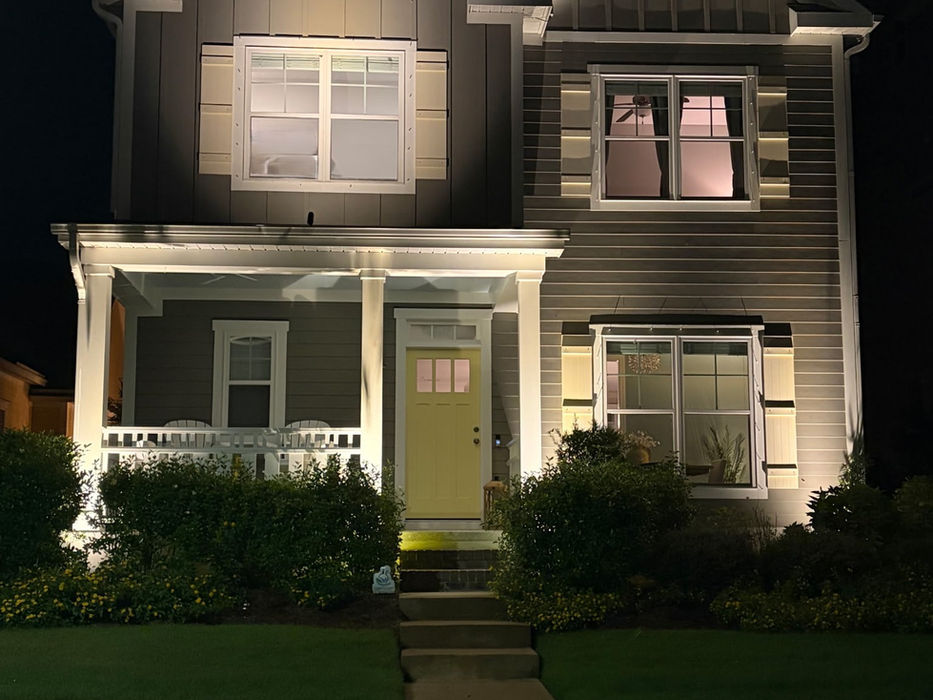 Two-story house illuminated by exterior lighting at night