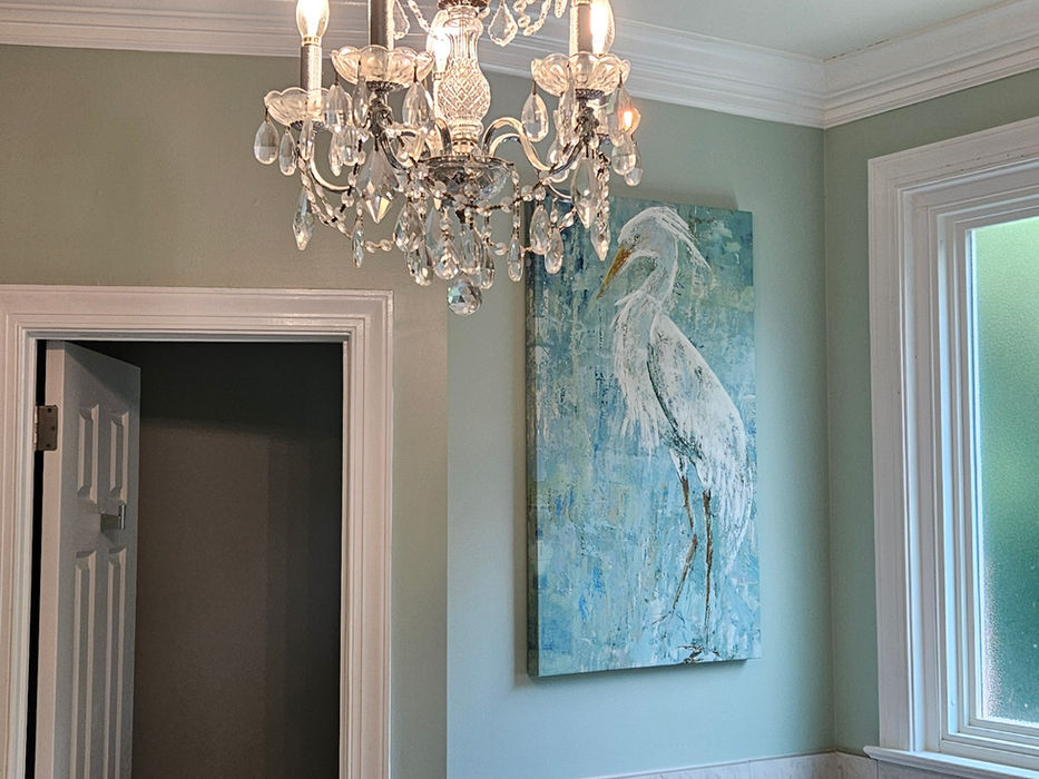 Elegant crystal chandelier in a bathroom with a white tub