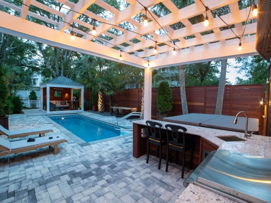 Outdoor patio with pool, pergola, and kitchen area