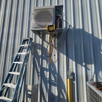 HVAC unit installation on a metal warehouse wall