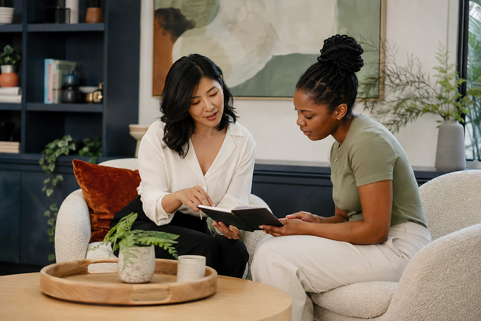 Two women reviewing a notebook together in a lounge.