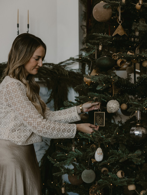 Natural Christmas tree decorated with warm lights and collected ornaments