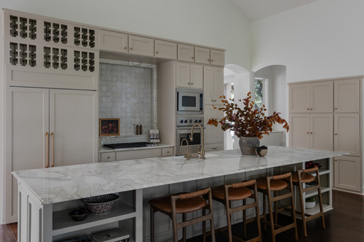 white marble kitchen countertops with vase with branches and wooden breakfast bar stools